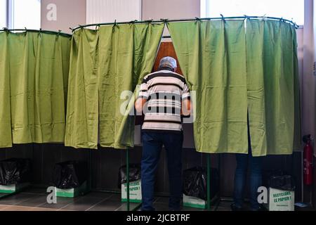 12 giugno 2022, Cours la Ville, Auvergne Rhone Alpes, Francia: Un uomo entra in una cabina di voto. Il popolo francese è chiamato a votare per il primo turno delle elezioni legislative che eleggeranno i deputati che siederanno all'Assemblea nazionale. Qui, in un seggio di Cours-la-Ville la Domenica mattina. (Credit Image: © Adrien Fillon/ZUMA Press Wire) Foto Stock