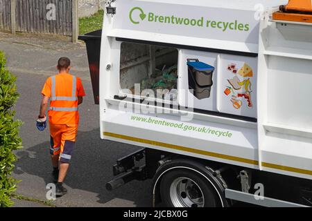 Riciclaggio degli alimenti conducente carrello indossando abbigliamento da lavoro ad alta visibilità e porta scorrevole aperta Brentwood Consiglio raccolta rifiuti caddy camion Essex Inghilterra UK Foto Stock