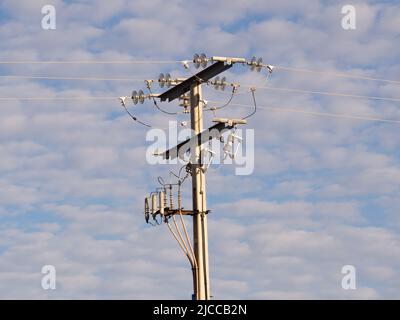 Linee elettriche ad alta tensione in un cielo blu e nuvole. Foto Stock