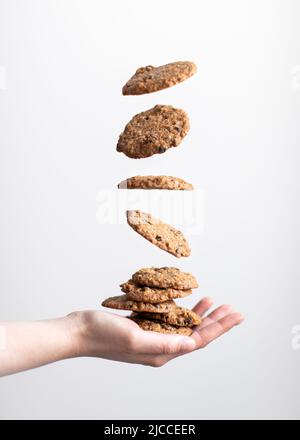 Levitazione dei cookie a portata di mano su sfondo bianco Foto Stock