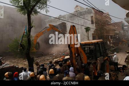 Prayagraj, India. 12th giugno 2022. Bulldozer che è usato da Prayagraj autorità di sviluppo amministrazione per demolire la residenza illegalmente costruita del cospiratore principale di protesta violenta e di pietra pelando la domenica a Prayagraj, India. Le proteste sono scoppiate in diverse parti del paese venerdì (10 giugno 2022) contro il portavoce del partito Bharatiya Janata hanno ora sospeso il commento derogatorio di Nupur Sharma sul Profeta Muhammad. Le proteste nel Prayagraj di Utttar Pradesh e in altri stati si sono trasformate in violente dove la polizia ha dovuto ricorrere alla lathi-carica. Credit: Anil Shakya/Alamy Live News Foto Stock