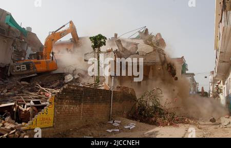 Prayagraj, India. 12th giugno 2022. Bulldozer che è usato da Prayagraj autorità di sviluppo amministrazione per demolire la residenza illegalmente costruita del cospiratore principale di protesta violenta e di pietra pelando la domenica a Prayagraj, India. Le proteste sono scoppiate in diverse parti del paese venerdì (10 giugno 2022) contro il portavoce del partito Bharatiya Janata hanno ora sospeso il commento derogatorio di Nupur Sharma sul Profeta Muhammad. Le proteste nel Prayagraj di Utttar Pradesh e in altri stati si sono trasformate in violente dove la polizia ha dovuto ricorrere alla lathi-carica. Credit: Anil Shakya/Alamy Live News Foto Stock