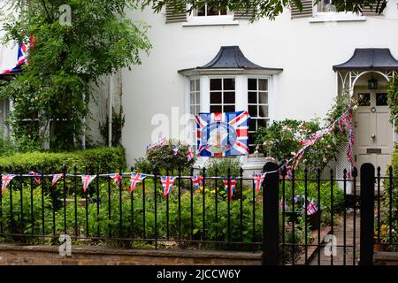 Windsor, Regno Unito. 4th giugno 2022. Union Jack che raggruppa e una bandiera sono raffigurate drappeggiata all'esterno di una casa residenziale per segnare il Platinum Jubil della Regina Elisabetta II Foto Stock