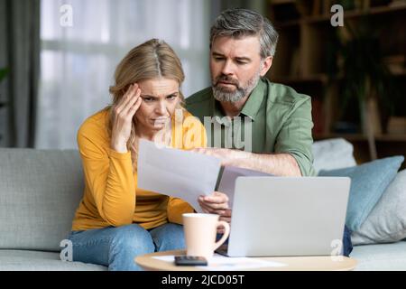 Ha sottolineato i coniugi di mezza età che hanno controllato i documenti finanziari nel paese Foto Stock