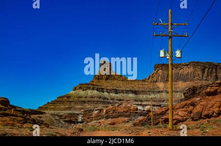 Palo in legno con fili elettrici sullo sfondo di formazioni geologiche stratificate di rocce rosse. USA Foto Stock