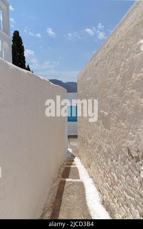 Vista del villaggio montano di Megalo Chorio, Tilos, stretto vicolo tra due immacolate pareti imbiancate. Dodecaneso, Rodi, Grecia Foto Stock