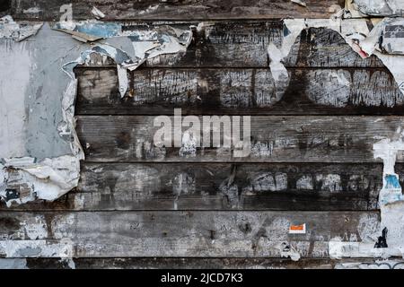 Vecchio bollettino bordo su parete rustica di legno con i resti di vecchia carta strappata dei manifesti, grunge sfondo Foto Stock