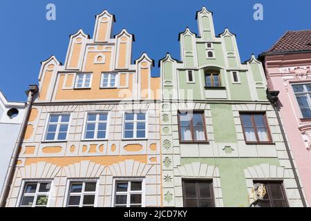 Landshut, Germania - 14 agosto 2021: Case storiche con facciata gialla e verde nel centro storico di Landshut. Foto Stock