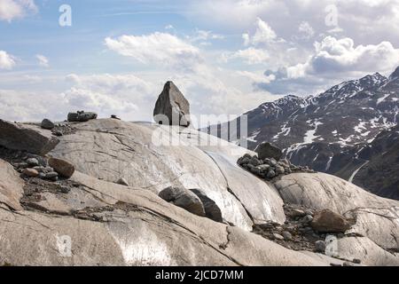 Paesaggio minimo nelle alpi. Terreno arido in alta montagna, pietra stand sul versante roccioso. Splendida natura in cima a una montagna. Foto Stock