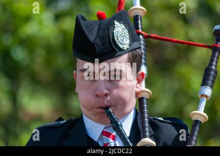 Ardrossan, Scozia, Regno Unito. 12th giugno 2022. Solo piping concorrenza al Ardrossan Highland Games come fa un ritorno dopo un due anni di assenza a causa della pandemia di Covid-19. I giochi celebrano la cultura scozzese con gare di pipe band solisti, balli highland e tradizionali eventi di pesi massimi. Credit: SKULLY/Alamy Live News Foto Stock