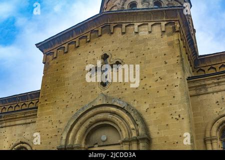 Tracce di pallottole e di shrapnel sul muro di una vecchia chiesa cristiana Foto Stock