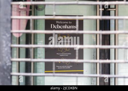 Benvenuti a Debenhams, segno con le linee guida COVID-19 visto attraverso le persiane chiuse del negozio Manchester Market Street. 'Morte della strada alta'. REGNO UNITO Foto Stock