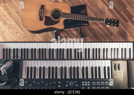 Tasti pianoforte e chitarra acustica, vista dall'alto. Foto Stock