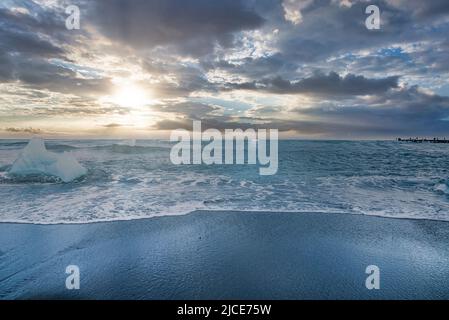 Vista panoramica delle onde che precipitano sulla spiaggia di sabbia nera di Diamond Beach contro il cielo Foto Stock