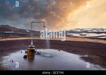 Doccia termale calda dalla potenza geotermica a Krafla contro la montagna Foto Stock