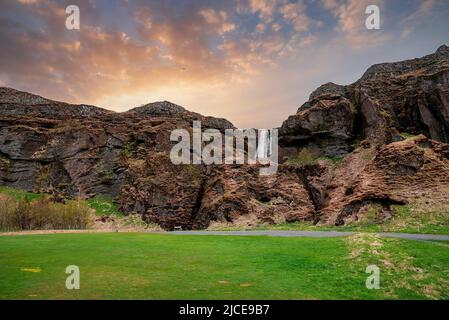 Vista panoramica di Gljufrafoss tra le montagne in valle contro il cielo al tramonto Foto Stock