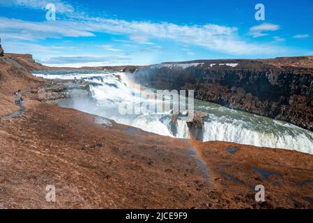 I turisti esplorano la splendida cascata Gullfoss nel cerchio d'oro contro il cielo Foto Stock