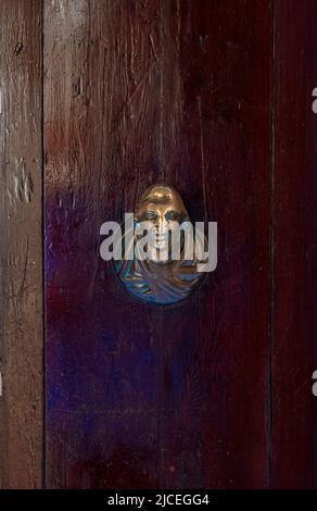 Maniglia porta in ottone ornamentale su porta con intemperie a Venezia, Italia Foto Stock
