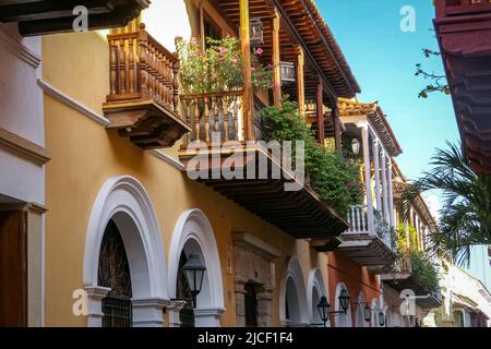 Vista su artistici balconi in legno di case storiche in una strada stretta a Cartagena, Colombia Foto Stock