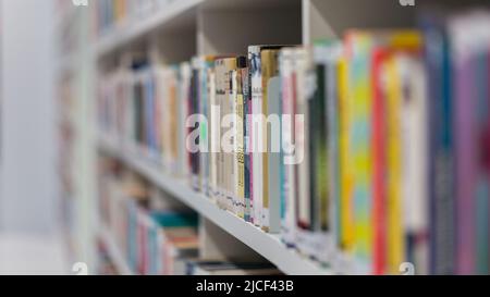 Stoccarda, Germania - Nov 16, 2021: Vista laterale sui libri in una libreria. All'interno di una biblioteca pubblica. Simbolo per la lettura e la letteratura. Foto Stock