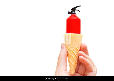 Estintore giocattolo all'interno di un cono di cialda per gelato in mano isolato su sfondo bianco. Rinfrescarsi durante l'estate calda. Foto Stock