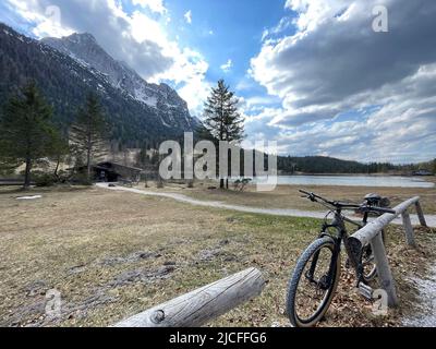 Ferchensee e Wetterstein nel mondo alpino Karwendel, montagne del Karwendel, bicicletta appoggiata contro recinzione, primavera, lago, chiosco, sentiero escursionistico, percorso ciclabile, nuvole, sole, montagne, natura, Mittenwald, Baviera, Germania Foto Stock