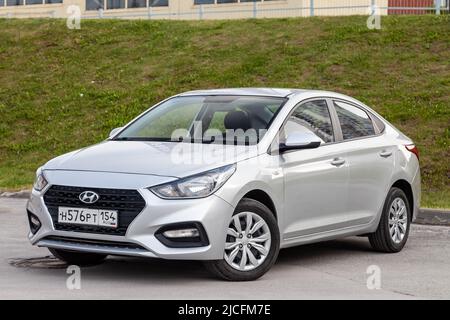 Novosibirsk, Russia - Marzo 09 2022: Vista frontale dell'argento Hyundai Solaris è parcheggiata sulla strada su un caldo d Foto Stock