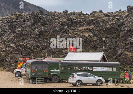 Il sentiero escursionistico di Laugavegur è il più famoso tour di trekking di più giorni in Islanda. Paesaggio girato dalla zona intorno a Landmannalaugar, punto di partenza del sentiero escursionistico a lunga distanza negli altopiani dell'Islanda. 'Mountain Mall' - piccolo supermercato basecamp in autobus. Foto Stock