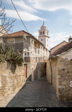 Vicolo con case tipiche e torre della chiesa nella piccola città di Skradin, contea di Sibenik-Knin, Dalmazia Centrale, Croazia, Europa Foto Stock