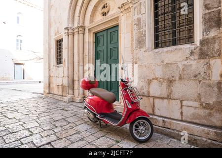 Scooter Vespa rosso nella città vecchia di Trogir, patrimonio mondiale dell'UNESCO, contea di Spalato-Dalmazia, Dalmazia, Croazia, Europa Foto Stock