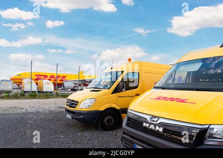 Schkeuditz, Germania - 29th maggio 2022 - molti furgoni corriere contro aerei da carico parcheggiati sul terminal dell'aeroporto di Leipzig Halle per la distribuzione del carico Foto Stock