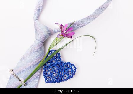 Composizione piatta con accessori per uomo, fiore e cuore su sfondo bianco. Foto Stock