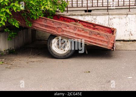 un vecchio rimorchio di carico dell'automobile per un'automobile del passeggero parcheggiata vicino alla casa Foto Stock