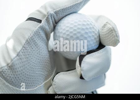 Palla da golf in mano a un giocatore. Sportivo che indossa il Golf Glove in mano. Primo piano. Foto Stock