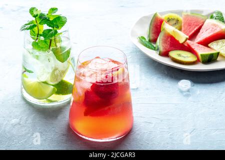 Cocktail estivi o mocktail freschi con frutta e ghiaccio, una festa di vacanza con cocomero, fragole e limonate di agrumi Foto Stock