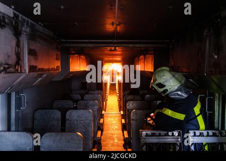 Langenhagen, Germania. 13th giugno 2022. Le fiamme si infiamparano durante un esercizio nell'abitacolo dell'impianto di simulazione incendio mobile del dipartimento dei vigili del fuoco dell'aeroporto di Hannover. Lo stabilimento è un progetto congiunto degli aeroporti di Hannover, Stoccarda e Brema ed è destinato a servire la formazione e l'esercizio dei vigili del fuoco degli aeroporti. Credit: OLE Spata/dpa/Alamy Live News Foto Stock