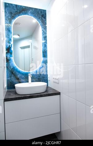 Interni in bagno contemporanei con specchio luminoso e tavolo lavabo Foto Stock