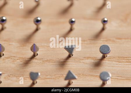 Bella gioielli piercing su display in legno. Scatto macro. Messa a fuoco selettiva Foto Stock