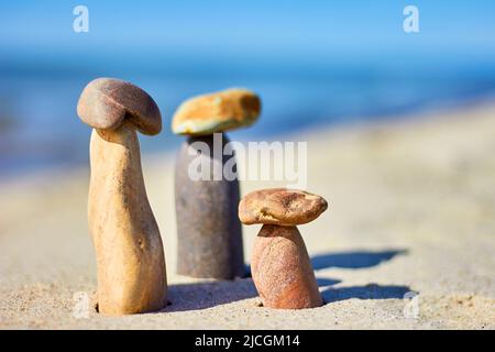 Tre funghi di pietra su una spiaggia sabbiosa. Equilibrio di pietre Foto Stock