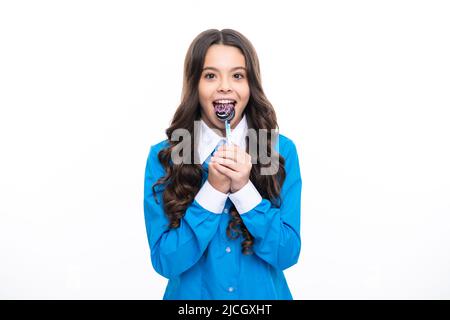 Ragazza adolescente con caramelle al caramello sui bastoni, dolce dipendenza da zucchero. Bambino con lollipops. Foto Stock