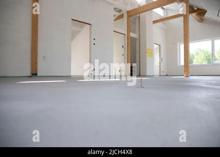 rasatore di calcestruzzo fresco su cantiere in loft in una casa di famiglia Foto Stock