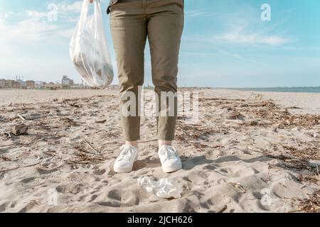 Attivista ambientale raccolta rifiuti sulla riva del mare Foto Stock