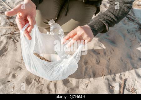 Volontario raccolta rifiuti sulla spiaggia di sabbia Foto Stock