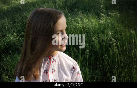Ritratto di una ragazza sorridente in una camicia ricamata all'aperto Foto Stock