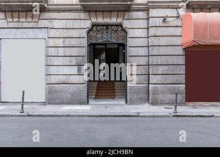 Portale di una casa residenziale con una facciata in pietra e paletti sul marciapiede Foto Stock