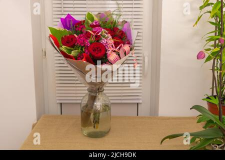 Primo piano di bel bouquet floreale con rose e altre varietà di fiori in una ciotola d'acqua Foto Stock