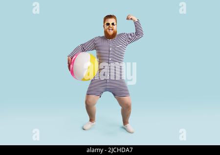 Allegro divertente chubby uomo con palla gonfiabile mostra i muscoli su sfondo azzurro chiaro. Foto Stock