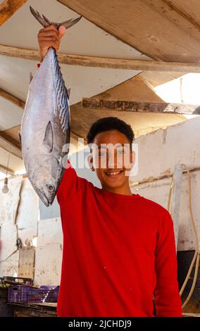 Hurghada, Egitto - 21 febbraio 2022: Venditore di pesce ragazzo felice Foto Stock