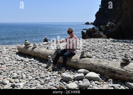 Pila di pietra o pila di roccia sulla spiaggia di ciottoli Catalogna, Spagna Foto Stock