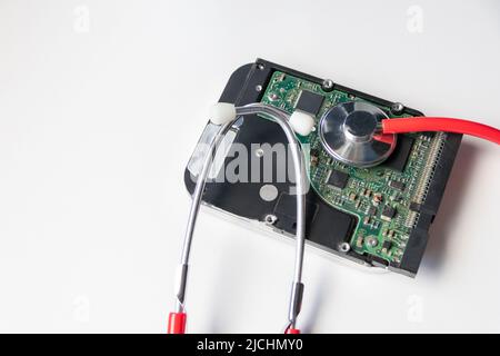 Lo stetoscopio rosso con unità disco rigido interna hdd contiene record di stato e dati paziente sensibili con controllo medico hardware e violazione dei dati di riposo Foto Stock